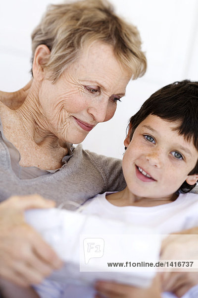 Senior woman giving present to little boy  indoors