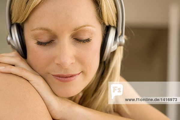 Junge Frau beim Musikhören mit Kopfhörern