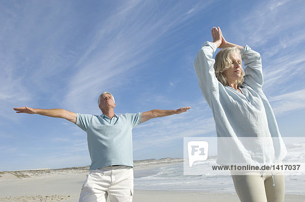 Couple in yoga attitude on the beach  outdoors