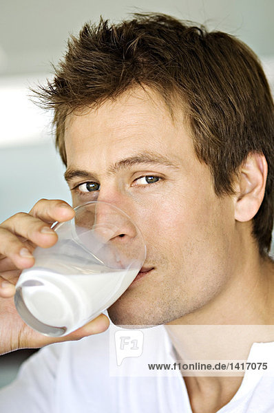 Porträt eines Mannes  der ein Glas Milch trinkt.