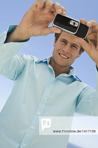 Portrait of a man using camera phone