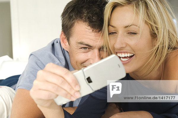 Junges Paar im Bett  per Handy