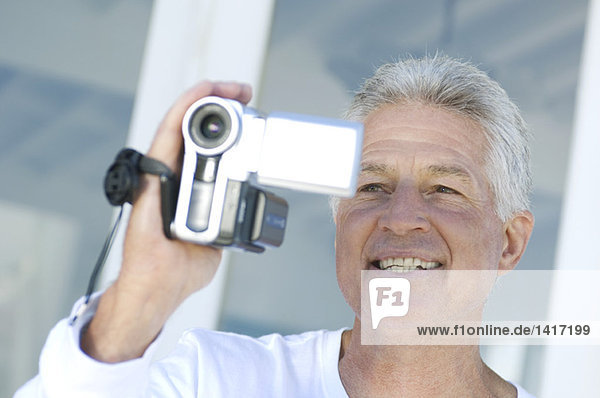 Portrait of a man using camcorder