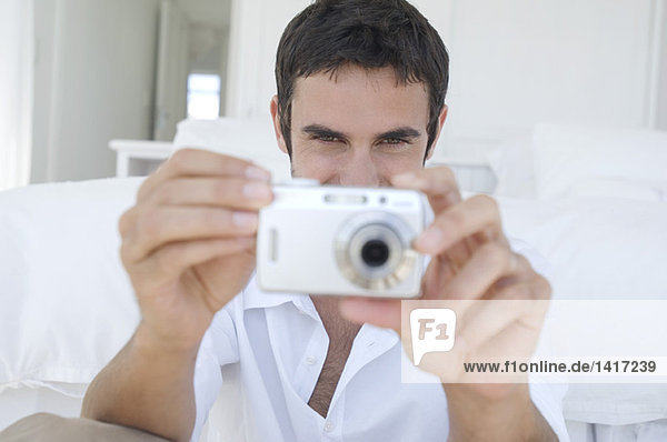 Young man using digital camera