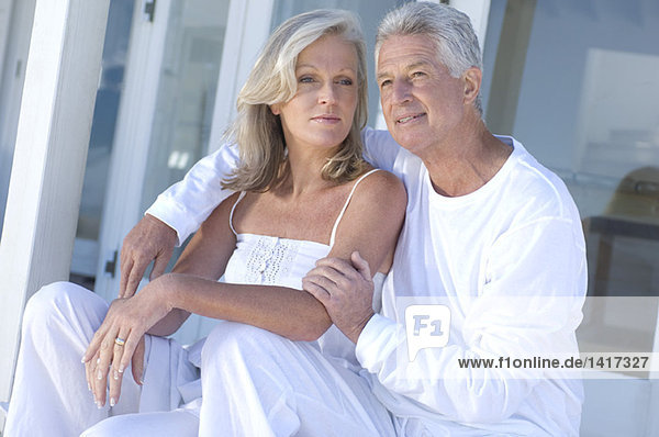 Embracing couple sitting on terrace