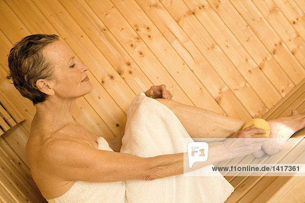 Seniorin in der Sauna sitzend
