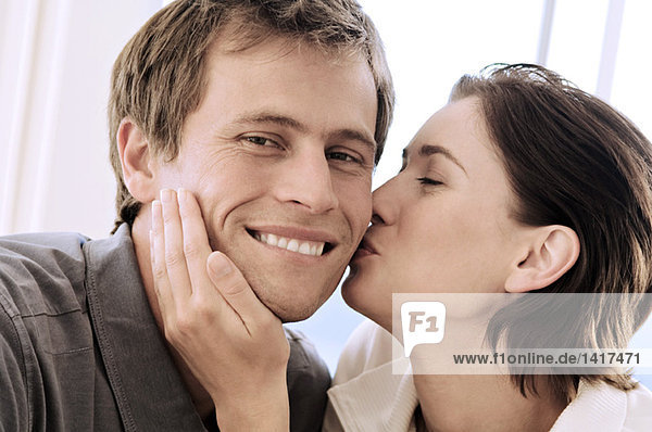 Portrait of woman kissing man
