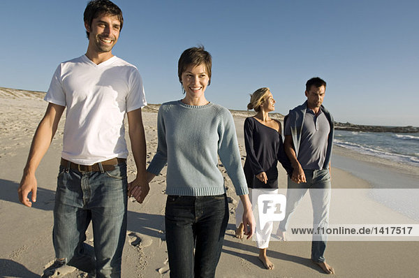 2 couples walking on the beach