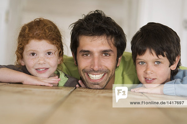 Vater und 2 Kinder lächeln für die Kamera