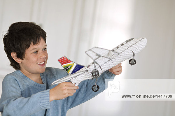 Little boy playing with model aeroplane