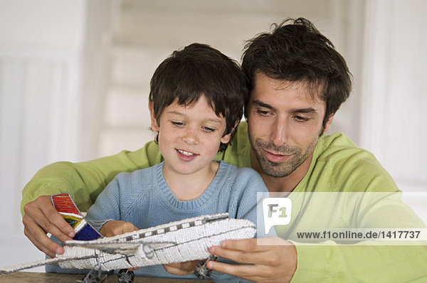 Vater und Sohn spielen mit dem Modellflugzeug