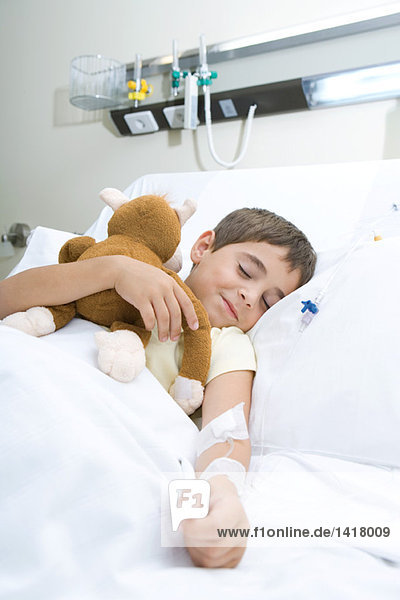 Junge schlafend im Krankenhausbett schlafend  Plüschtier haltend  lächelnd