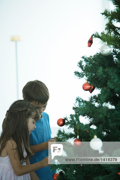 Kinder schmücken den Weihnachtsbaum