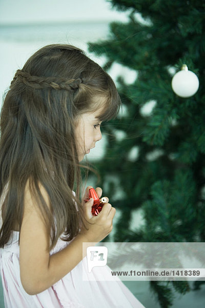 Mädchen schaut auf den Weihnachtsbaum