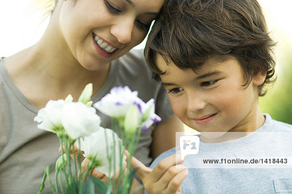 Mutter und Sohn schauen gemeinsam Blumen an