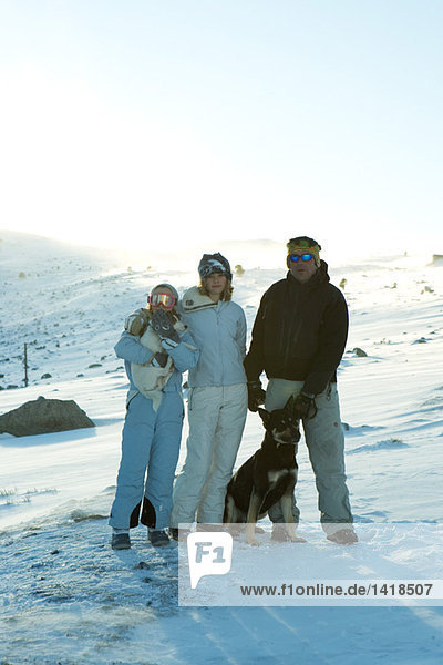 Skifahrer auf verschneiter Piste mit zwei Hunden