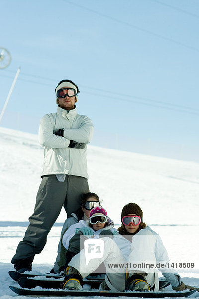 Young snowboarders on ski slope  full length portrait
