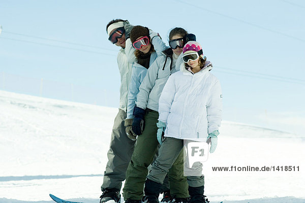 Young snowboarders standing on ski slope  full length portrait