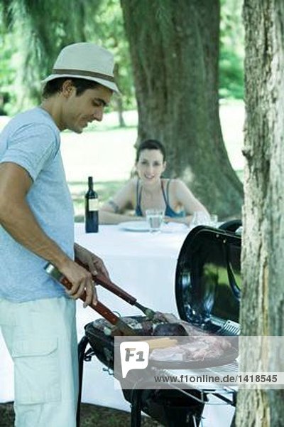 Mann beim Grillen von Fleisch auf dem Grill