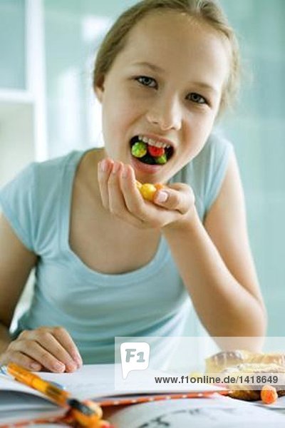 Mädchen essen Süßigkeiten und machen Hausaufgaben