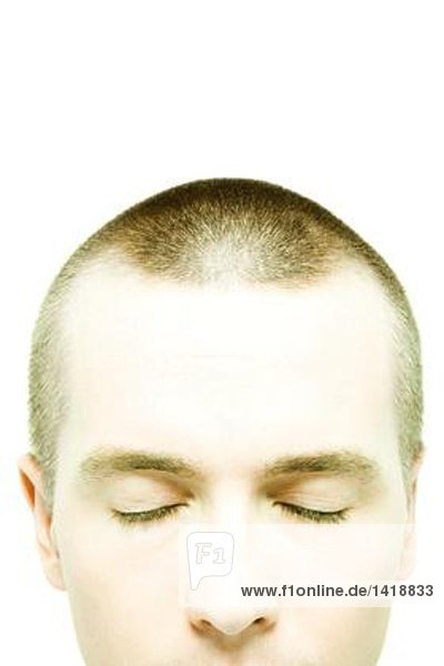 Junger Mann mit rasiertem Kopf  Augen geschlossen  Nahaufnahme