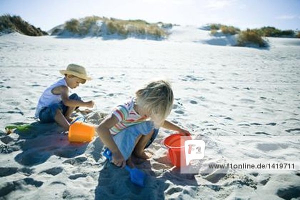 Kinder spielen im Sand