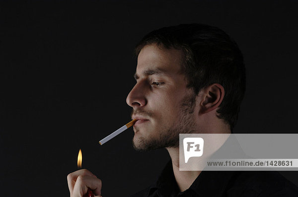 Mann beim Anzünden einer Zigarette  Porträt