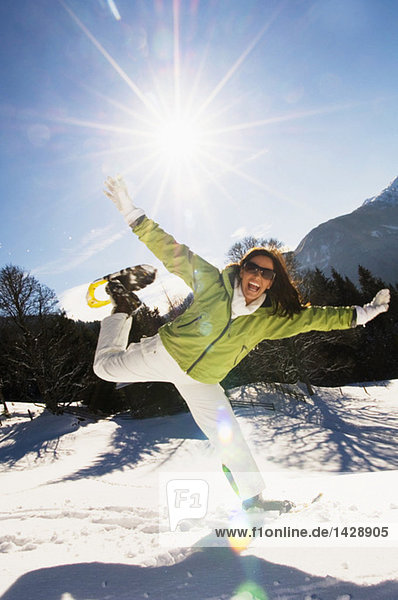 Frau mit Schneeschuhen  springend