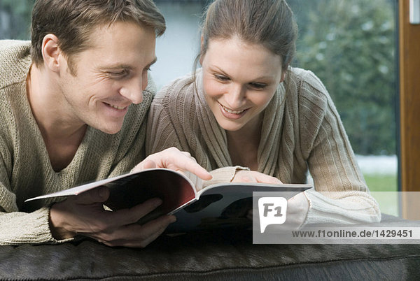 Young couple paging through a magazine