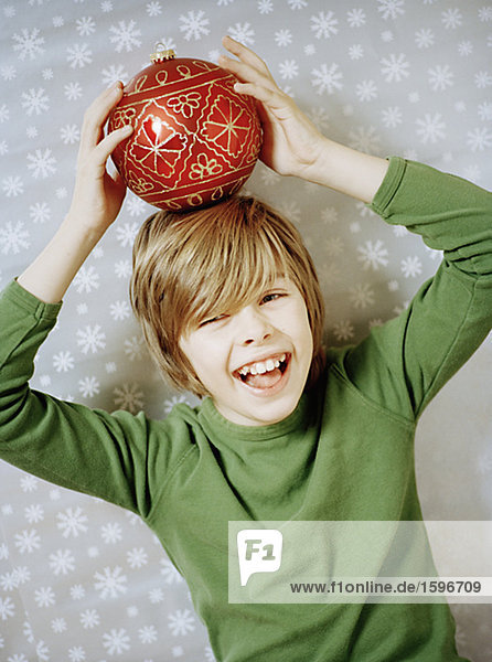 lächeln Junge - Person balancieren Weihnachtsbaum Tannenbaum Ball Spielzeug