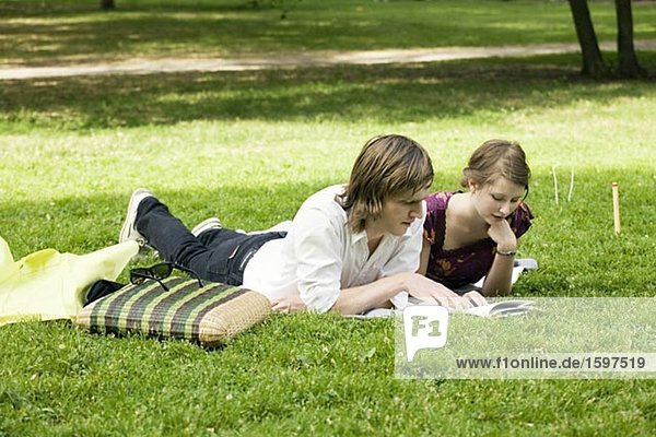 Young Scandinavian couple reading a book together outdoors Sweden.