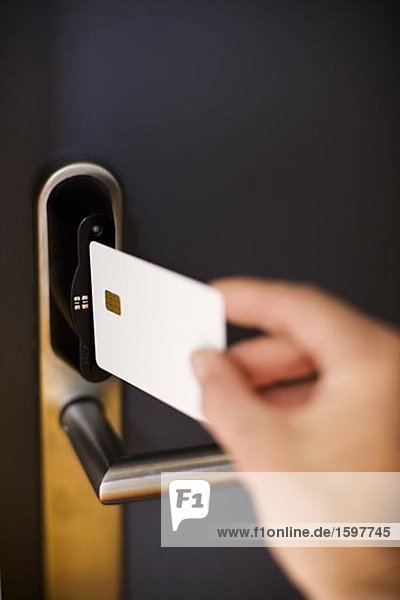 Eine Person eine Tür mit einem Schlüssel Karte entsperren.