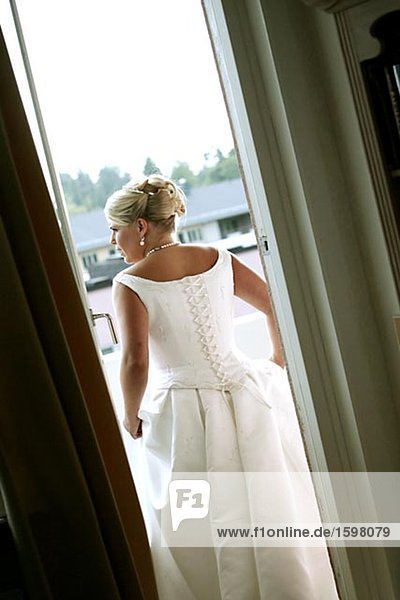 A Scandinavian woman wearing a wedding dress standing in a doorway Sweden.