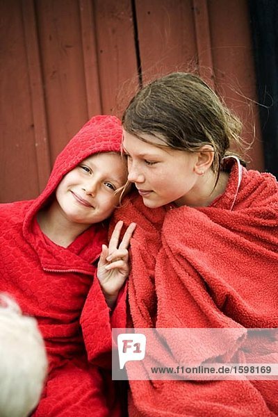 Two Scandinavian girls sitting with their towels wrapped around themselves Oland Sweden.