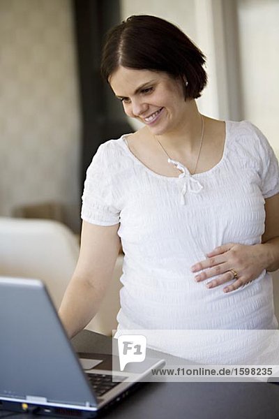 Eine schwangere Frau mit einem Laptop Schweden.