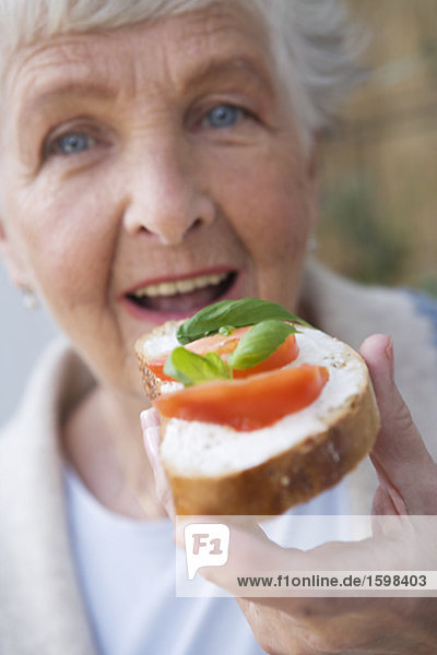 Woman having a sandwich with tomato and basil Sweden.