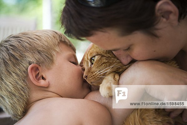 Eine skandinavische Boy und Erwachsenen cuddles mit einer Katze Mariefred Schweden.