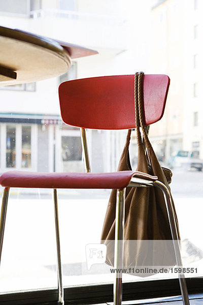 Ein Stuhl mit einer Tasche in ein cafÈ