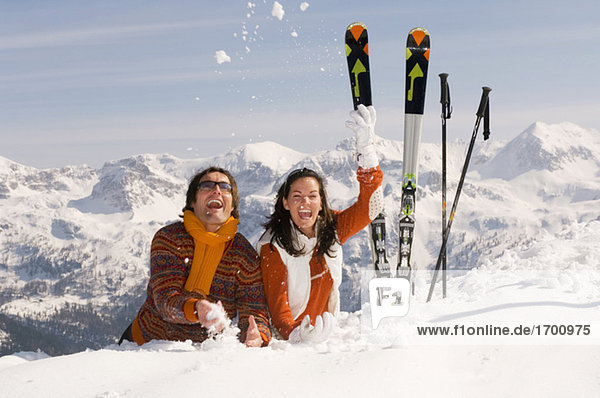 Paar in den Bergen  Schnee werfen