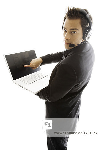 Junger Mann mit Kopfhörer,  hält Laptop,  Nahaufnahme