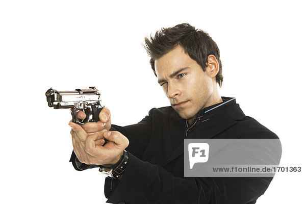 Young man holding hand gun  close-up