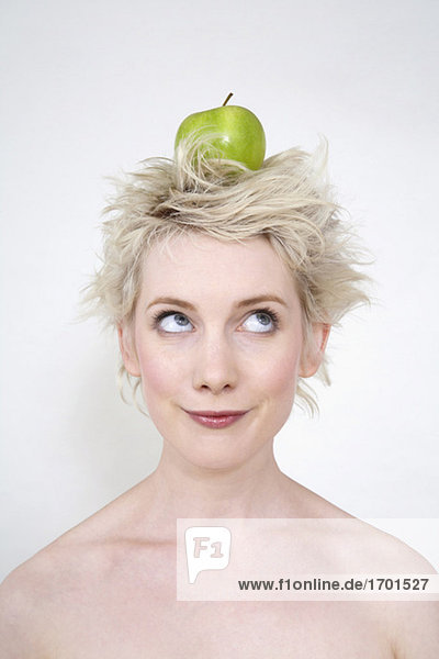 Junge Frau  die den Apfel auf dem Kopf balanciert  Porträt