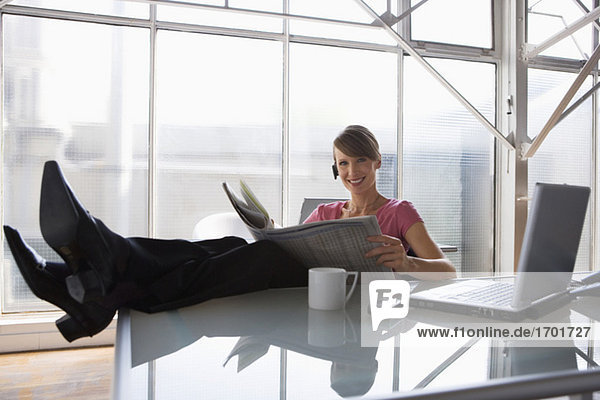 Business woman relaxing at her desk feet on table top