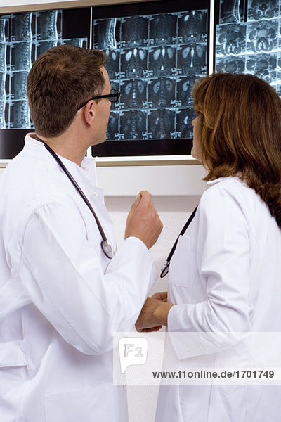 Male doctor and a female doctor examining an x-ray report