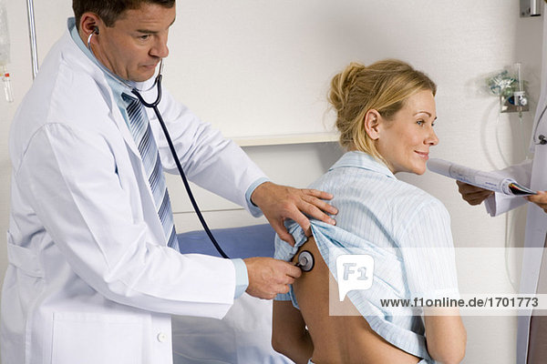 Doctor auscultating female patient