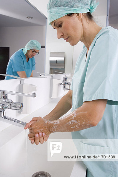Chirurgin und Chirurgin beim Händewaschen