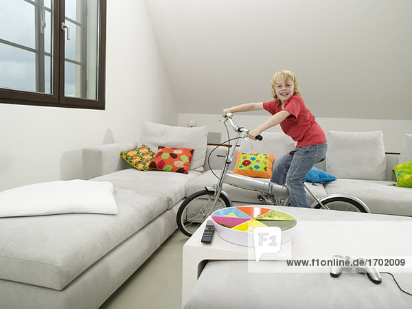 Boy cycling in living room