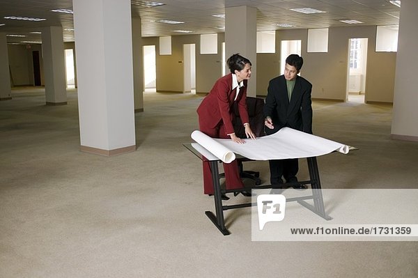 Firmen betrachten Blueprints in leeren office