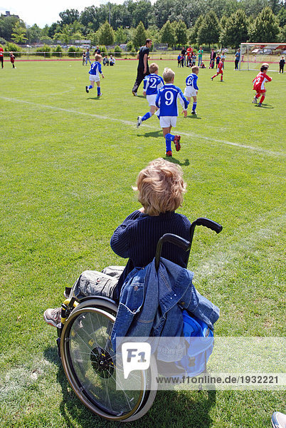 sitzend sehen Junge - Person Feld Rückansicht Ansicht Fußball spielen Rollstuhl