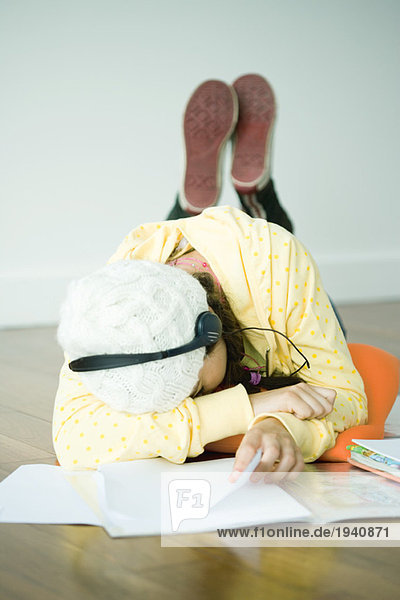 Young woman lying on floor listening to headphones  head on arm